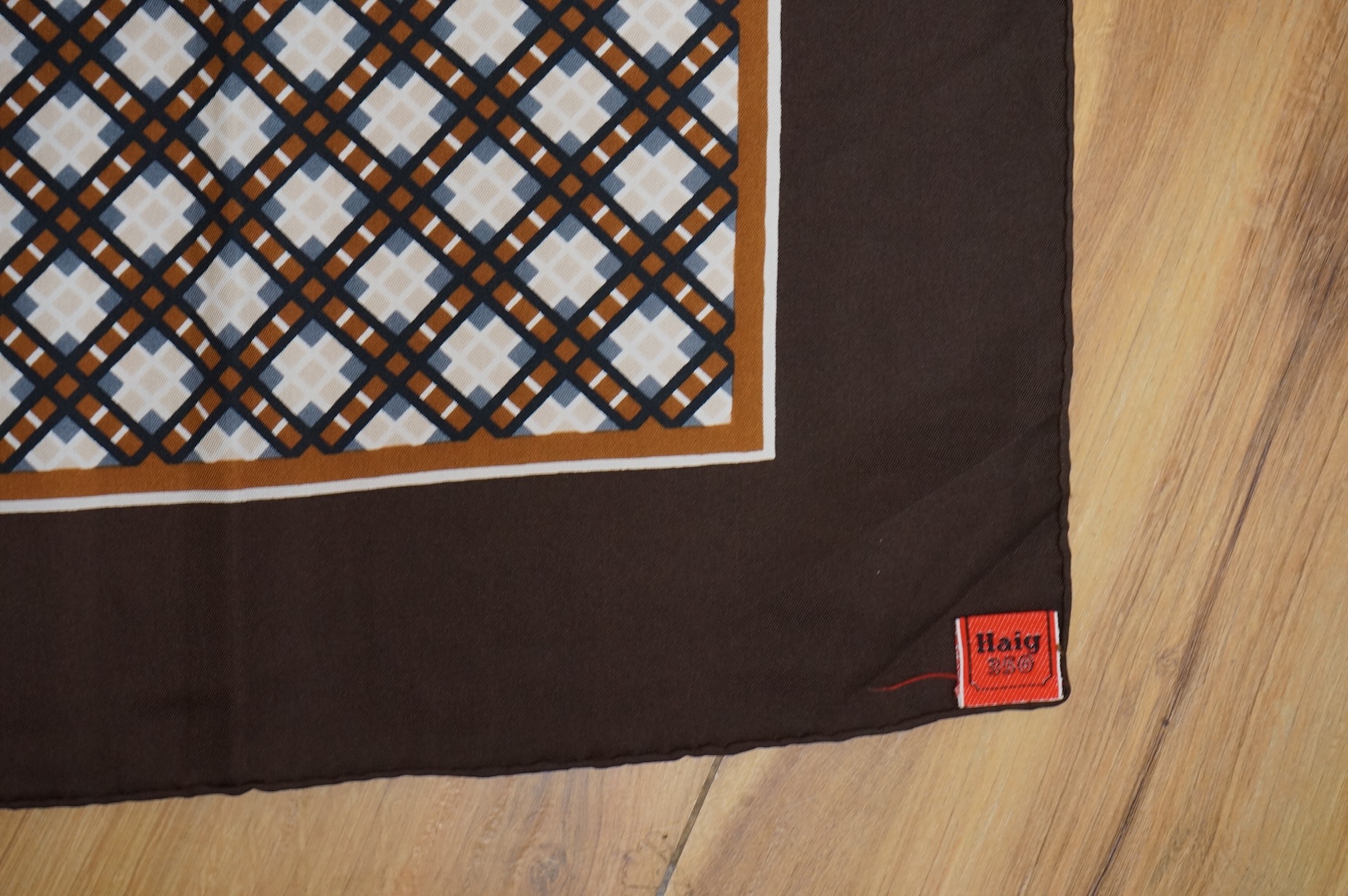 Two Yves Saint Laurent silk scarves comprising a monogrammed example and a patterned brown example with Foulards folding case